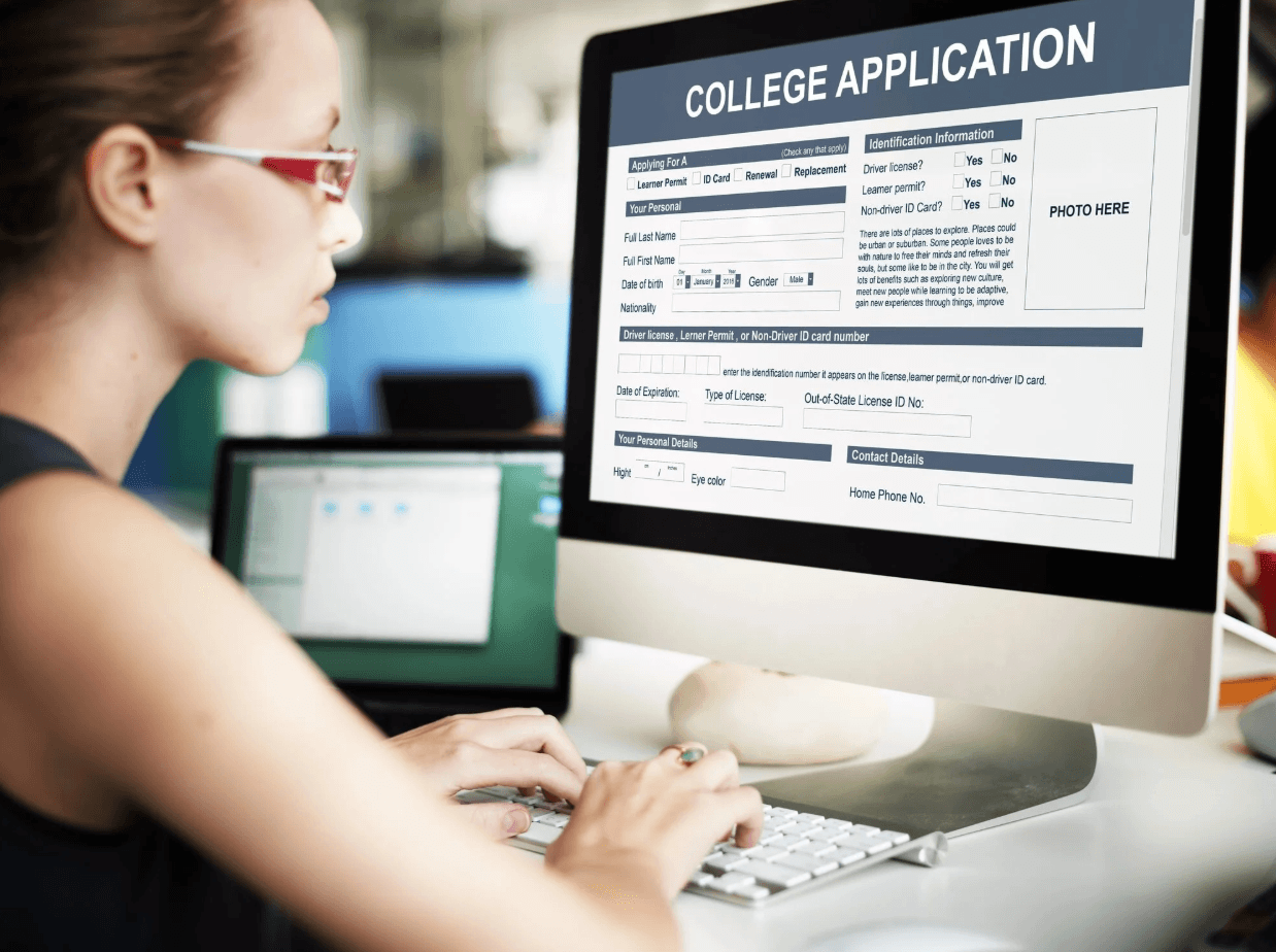A person filling out a college application form on a computer.