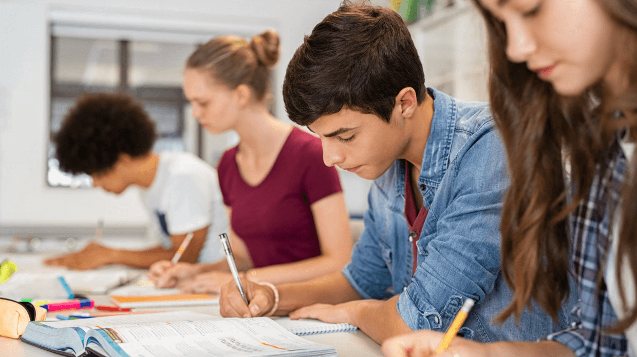A group of students focused on their studies at a table.