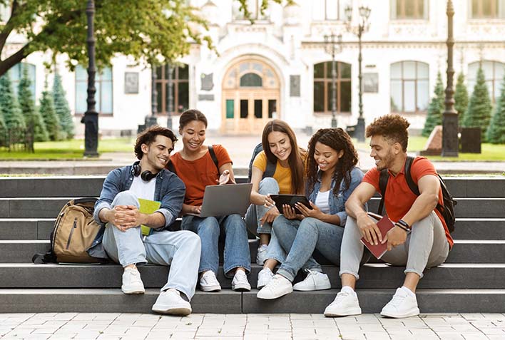 Growing Minds students sitting on the steps of the college.